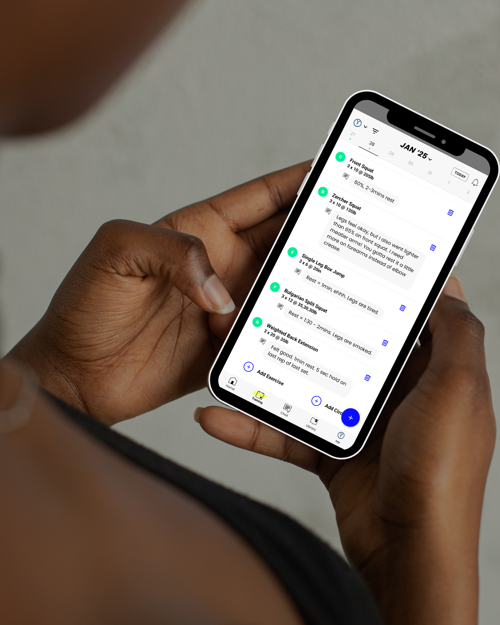 Woman Tracking Workout On Phone Using the TrainHeroic app to track workout